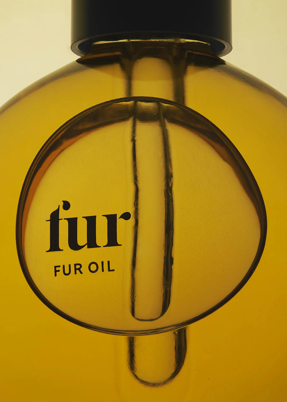 Close-up of a bottle labeled 'fur oil' with a yellowish liquid.
